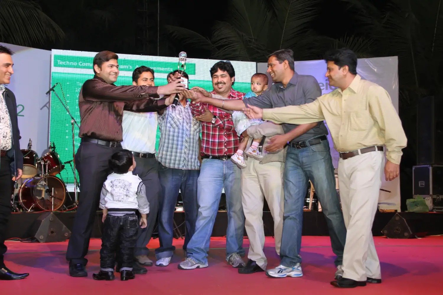 Man and woman speaking on stage at night with blue lighting